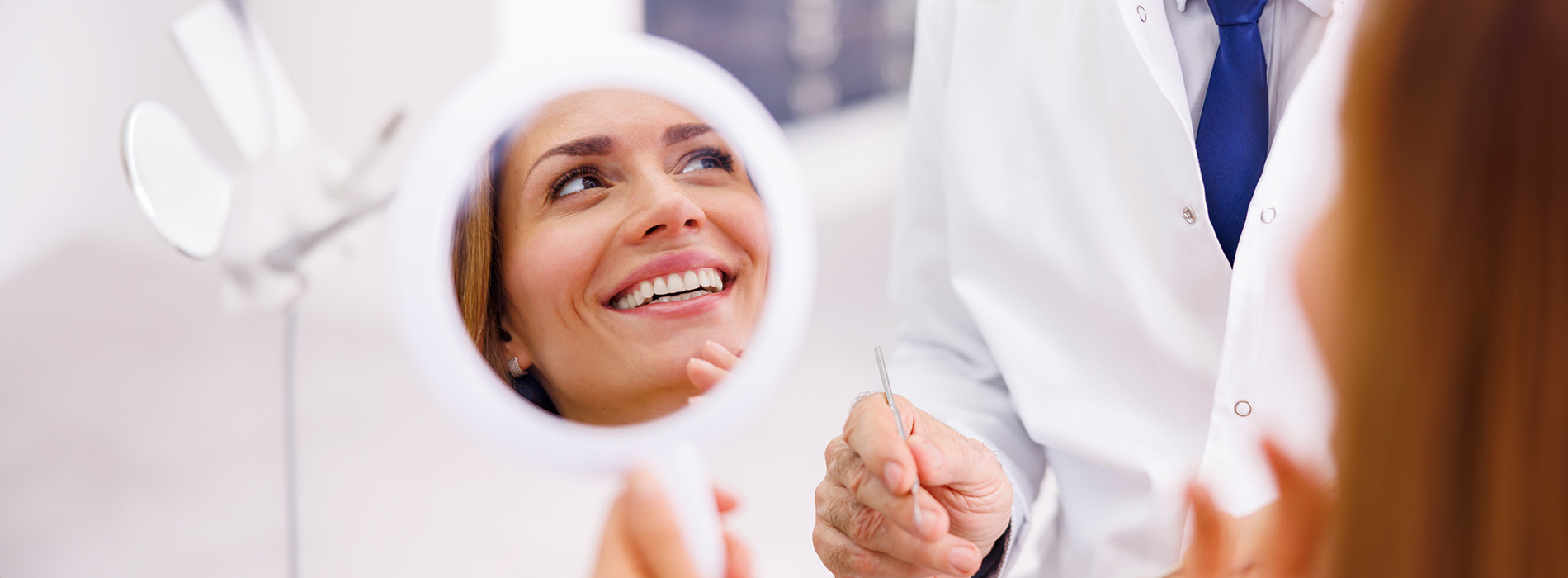 A well-lit reception area with a desk, computer monitor, and potted plant.